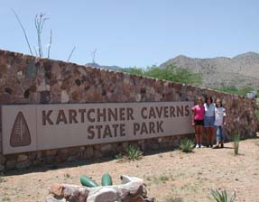 Kristin, Kathy, and Dani stand before the sign greeting visitors to Kartchner Caverns